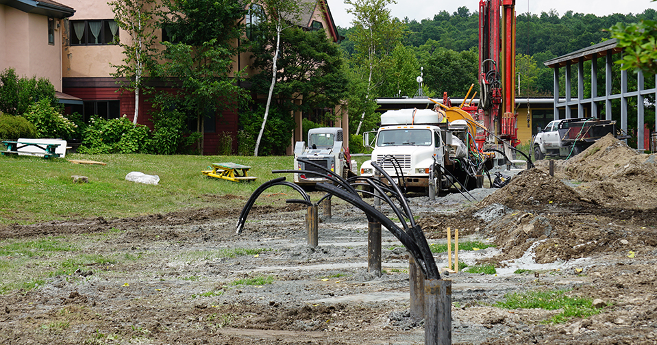 piping for the geothermal energy system with drill operating in the background
